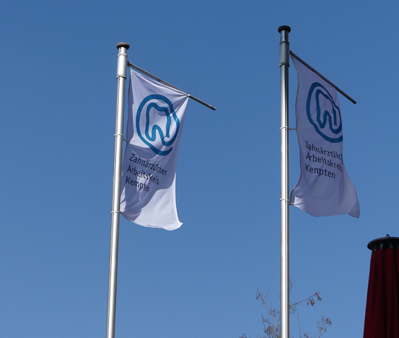 wehende Flaggen mit dem Logo des Zahnärztlichen Arbeitskreises Kempten